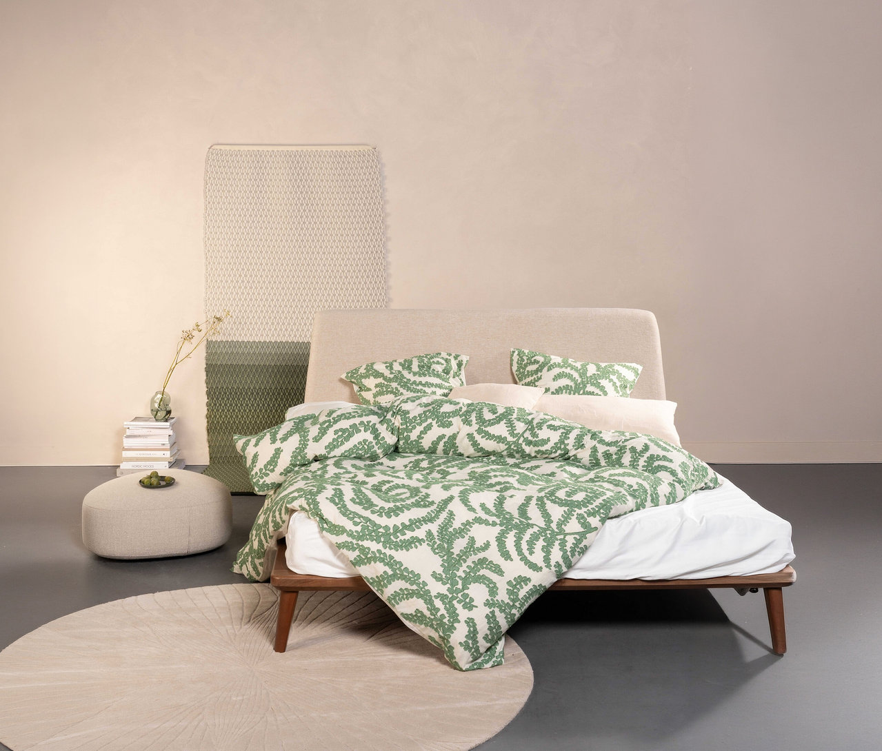Bett mit Essenza Satin-Bettwäsche »Eleria« in Normalgröße und Übergröße, mit grünem Blätterdruck, auf rundem Teppich.