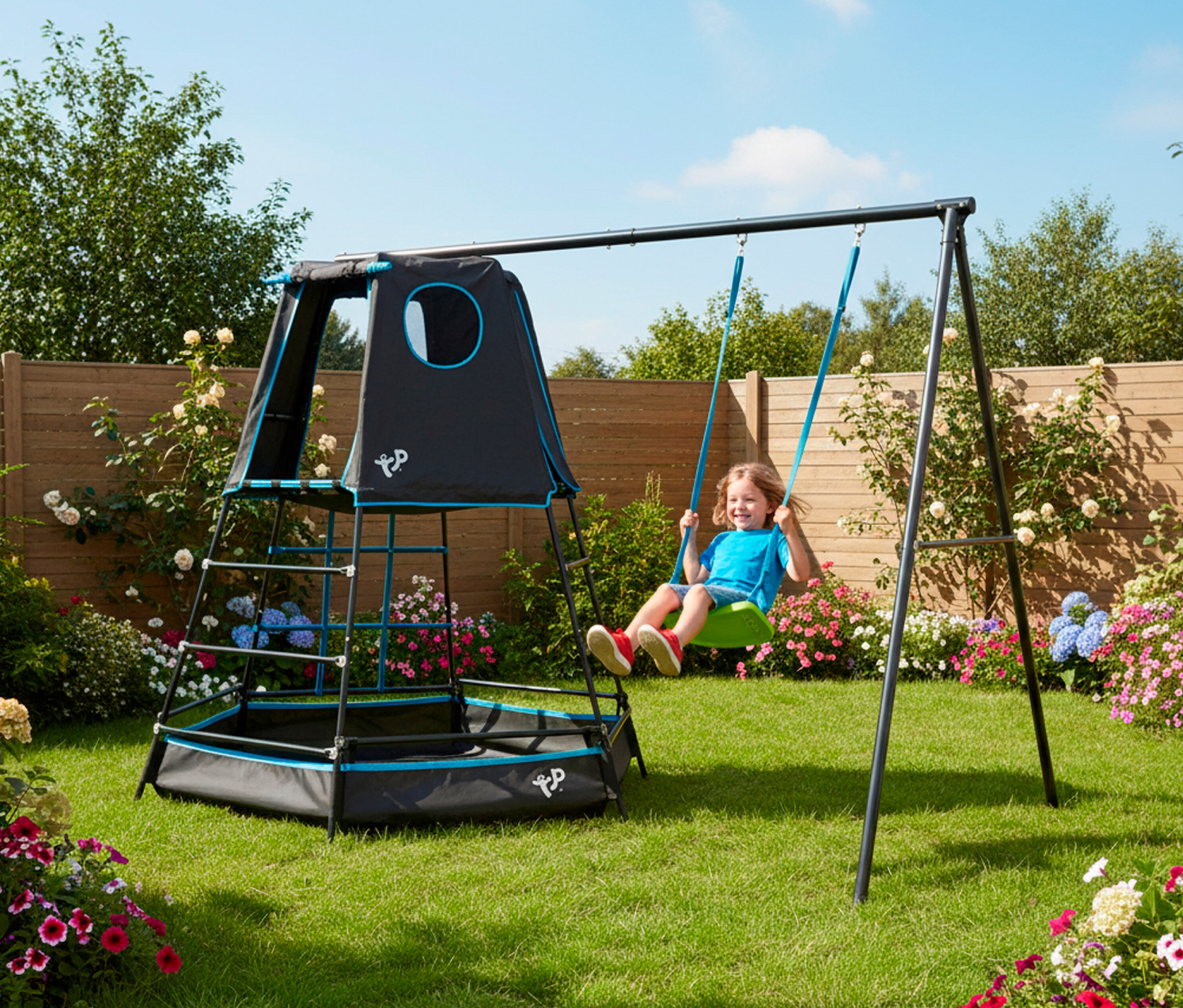 Ein Kind schwingt auf dem Kletterturm »Explorer« mit Schaukel im Garten.