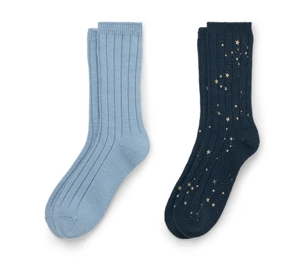 Zwei Paar gerippte Socken auf weißem Hintergrund. Das linke Paar ist hellblau. Das rechte Paar ist dunkelblau mit einem verstreuten goldenen Sternenmuster.