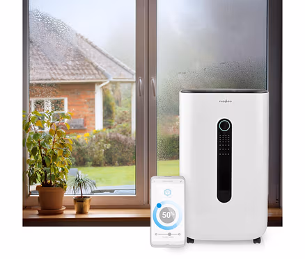 Weißer Nedis Smart Luftentfeuchter neben einem beschlagenen Fenster. Ein Smartphone zeigt die App mit 50% Luftfeuchtigkeit an.