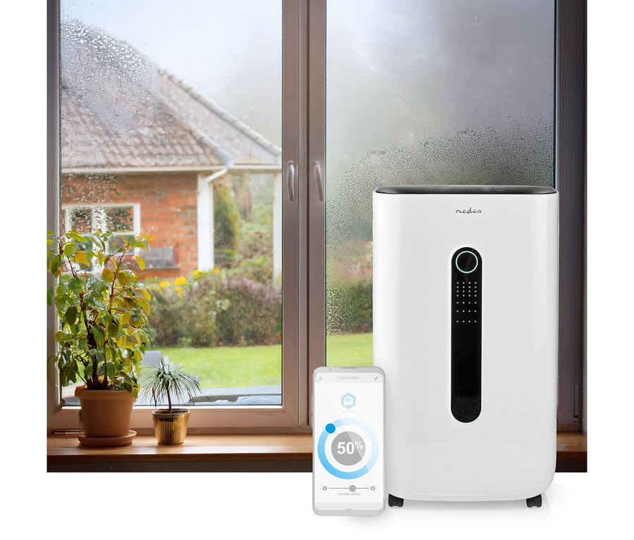 Weißer Nedis Smart Luftentfeuchter neben einem beschlagenen Fenster. Ein Smartphone zeigt die App mit 50% Luftfeuchtigkeit an.