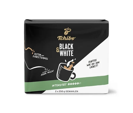 Schwarze und weiße Tchibo BLACK & WHITE 500 g Gemahlen Kaffeepackung mit einer Tasse Kaffee und Milchschaum.