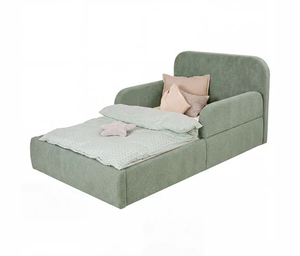 Grünes Kinderschlafsofa, ausgeklappt als Bett, mit hellgrüner Bettdecke, drei Kissen und einem sternförmigen Plüschtier.
