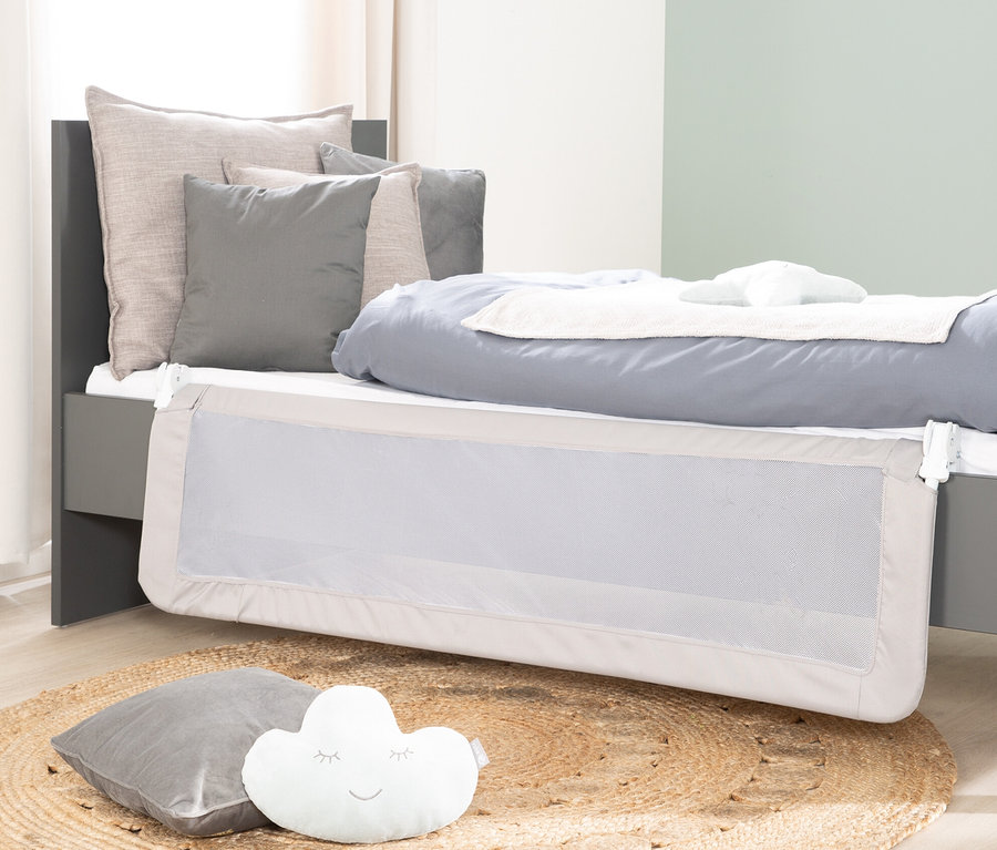 Graues Bett mit grauem roba Bettschutzgitter »Klipp-Klapp«, Kissen und rundem Teppich.