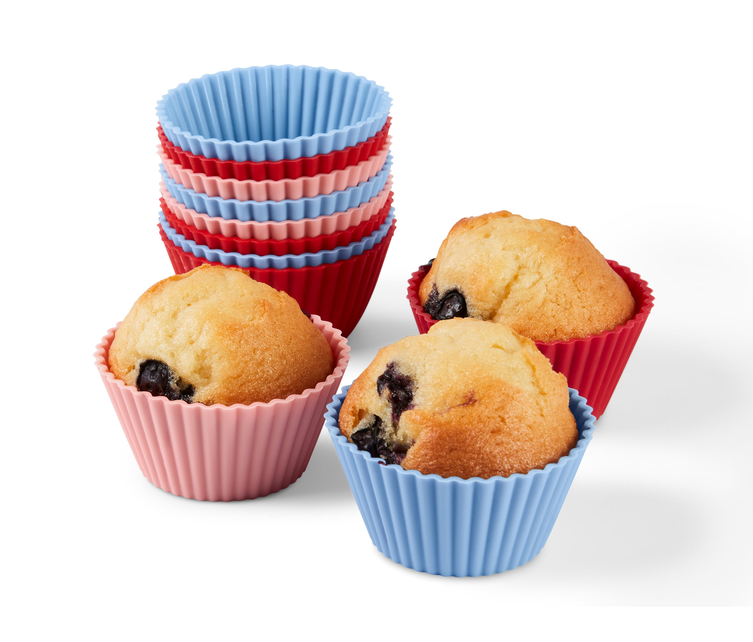 Drei Muffins in roten, rosa und blauen 12 Muffinförmchen und ein Stapel Muffinförmchen.