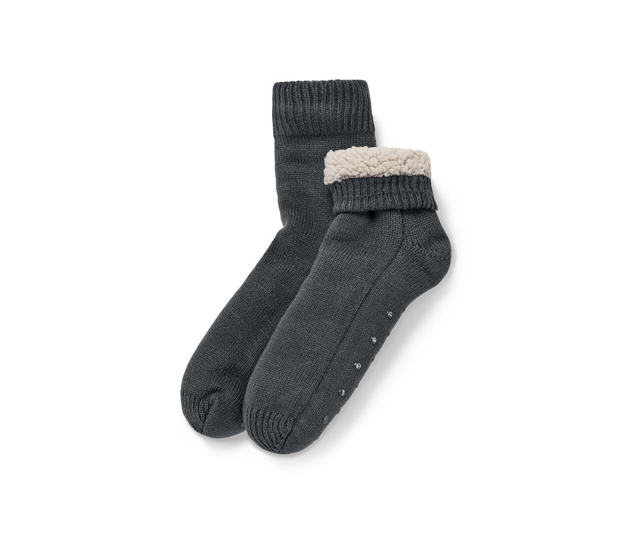 Zwei Hausschuh-Socken liegen übereinander, eine davon ist umgeschlagen und hat einen Plüschrand.