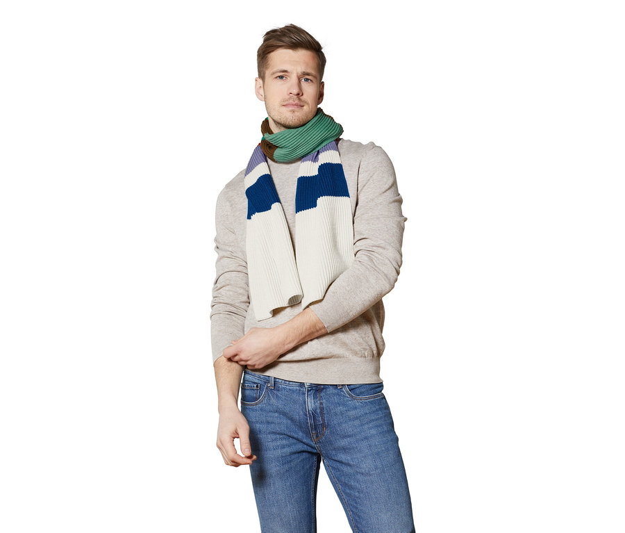 Mann trägt einen Strickschal mit bunten Streifen.