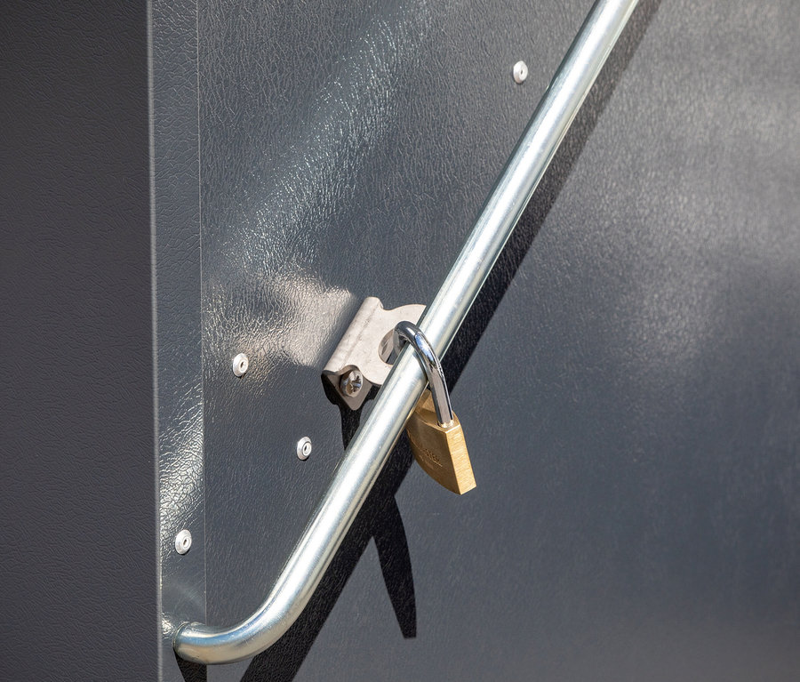 Detailansicht einer grauen Gerätebox »Storeguard« mit Vorhängeschloss an einem silbernen Griff.