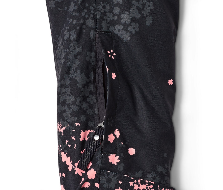 Detail einer schwarzen Halfzip-Skijacke mit Blumenmuster und teilweise geöffnetem Reißverschluss.