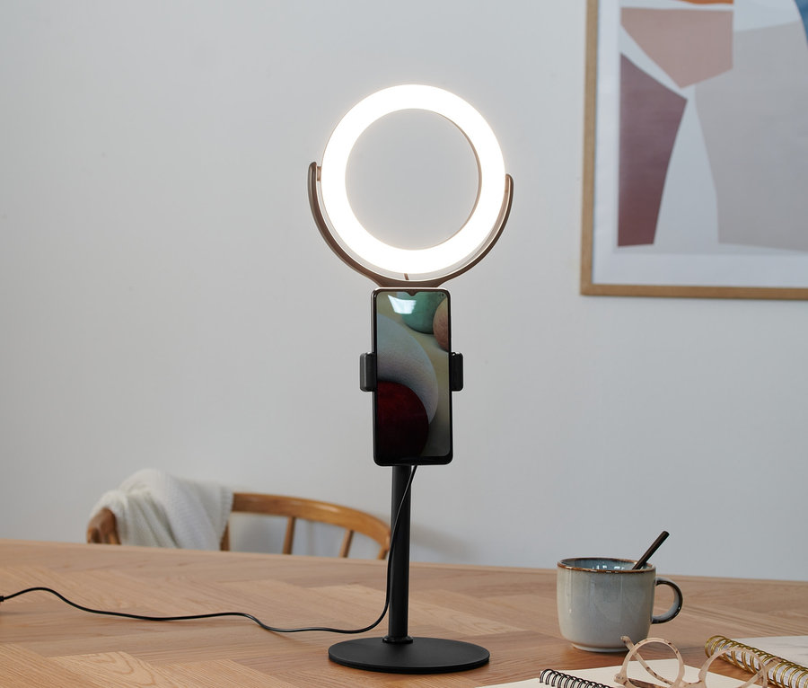 Auf einem Tisch steht ein 8-Zoll-LED-Selfie-Ringlicht mit Standfuß und einem Telefon.