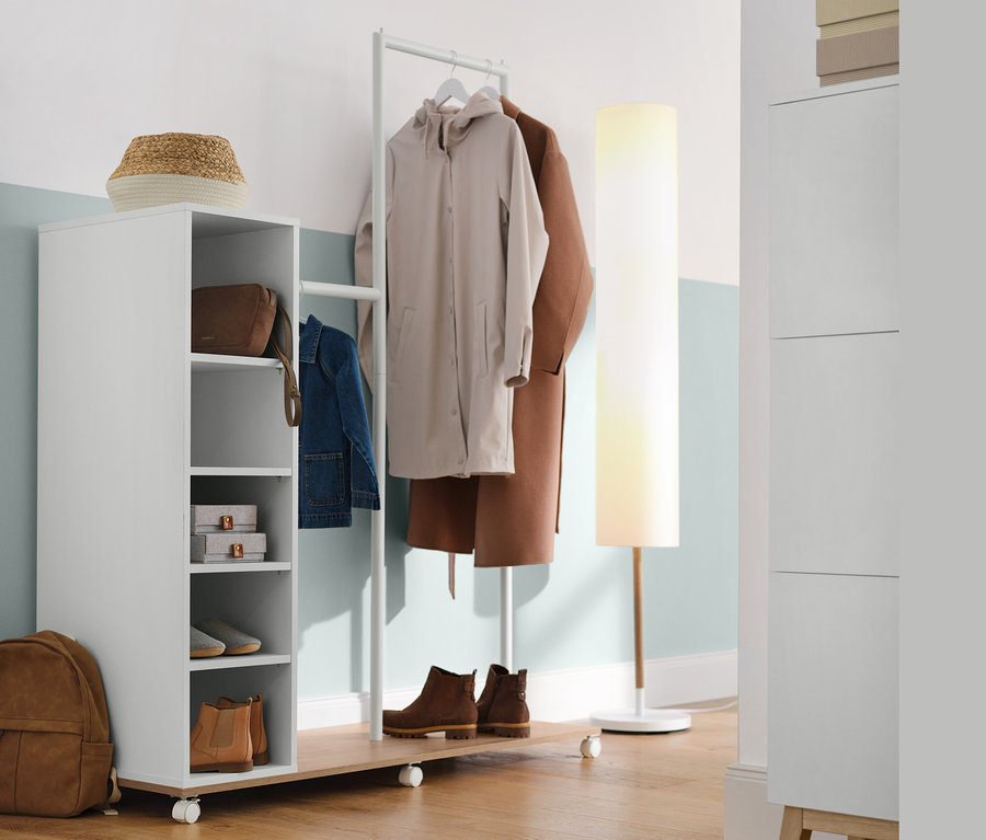 Eingangsbereich mit Aufbewahrungskorb, Garderobe mit Fächern und verschiedenen Ebenen und Stehleuchte mit Textilschirm.