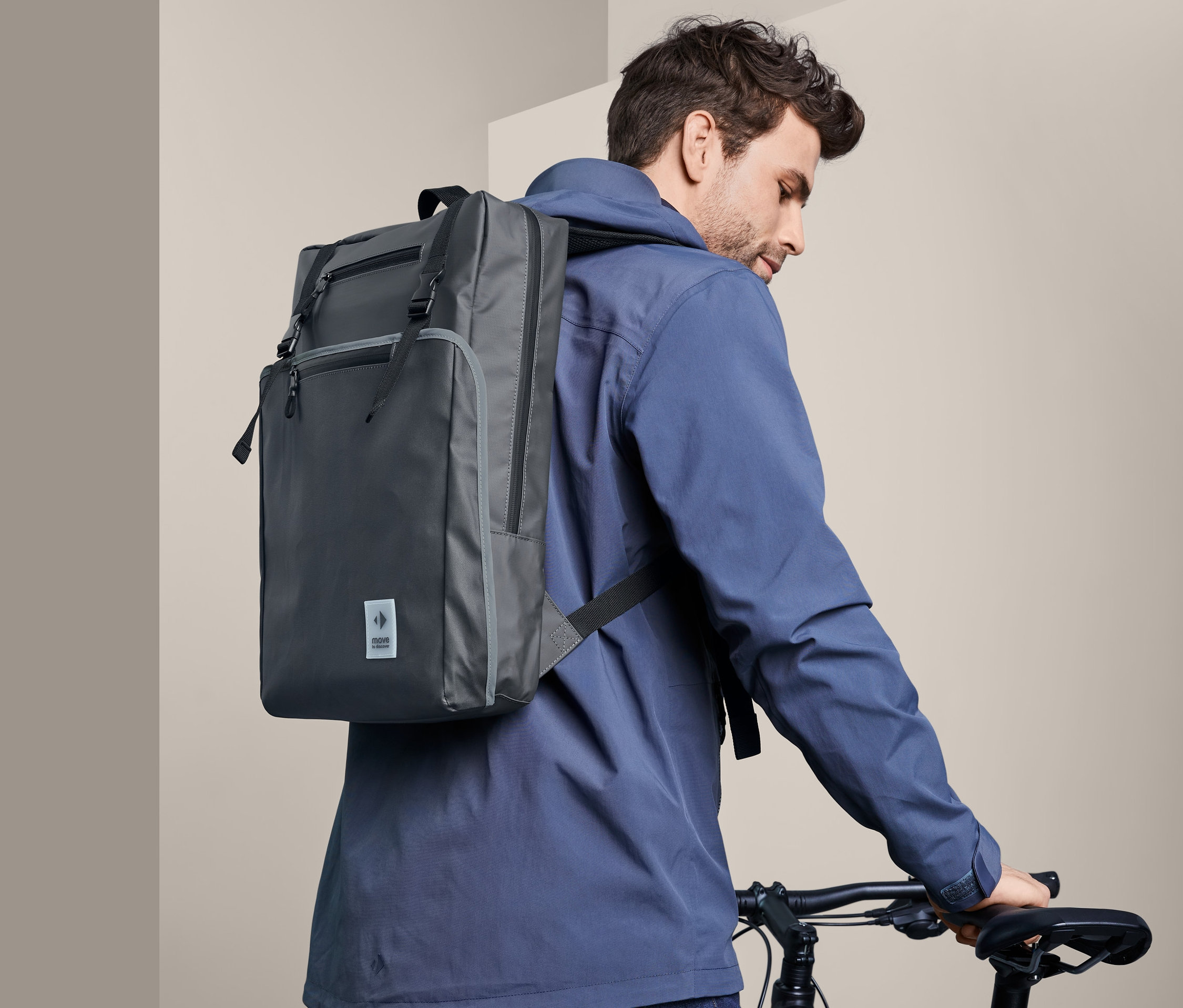 Mann geht mit Fahrrad und trägt einen Fahrrad-Rucksack.