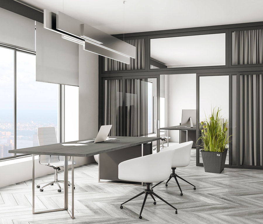 Büro mit grauem Tisch, weißen Stühlen und anthrazitfarbenen 2 XL-Pflanzgefäßen aus Polyrattan.