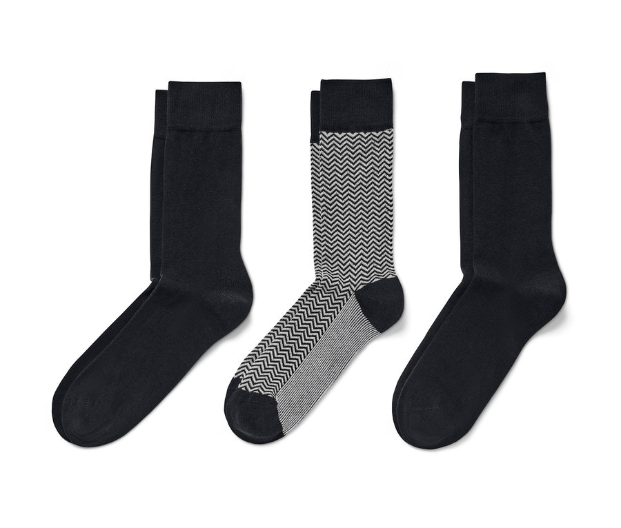 Drei Paar Socken: zwei Paar schwarz, ein Paar gemustert.