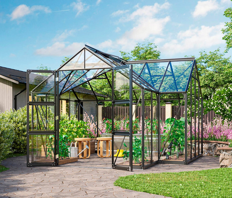 Ein Vitavia Gewächshaus mit 13 m², inklusive Fundamentrahmen, steht auf einer gepflasterten Terrasse.