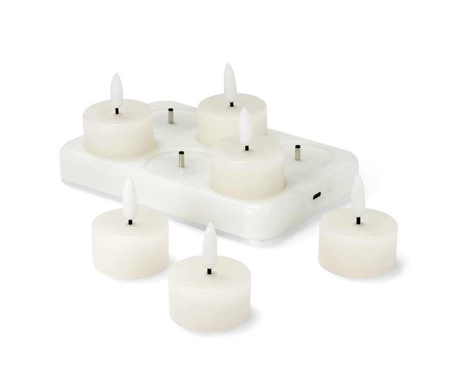 Sechs LED-Echtwachsteelichter mit Akku stehen auf einer weißen Ladestation.