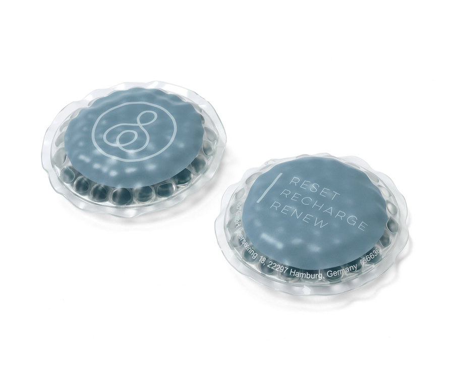 Zwei Augen-Kühlpads, eines mit Logo, eines mit dem Schriftzug 'RESET RECHARGE RENEW'.