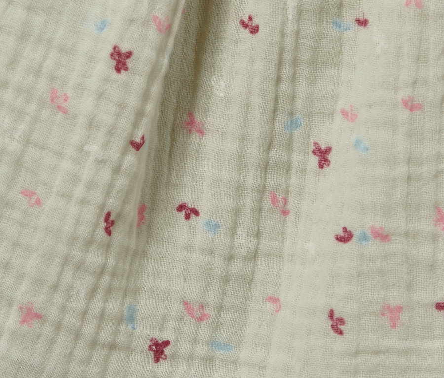 Detailaufnahme eines Baby-Webkleids mit kleinen Blümchen.