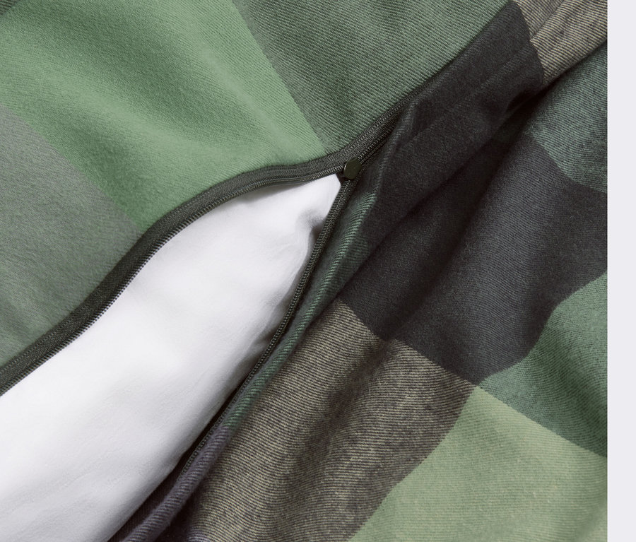 Detail einer Flanell-Bettwäsche mit Reißverschluss und grünem Karomuster.