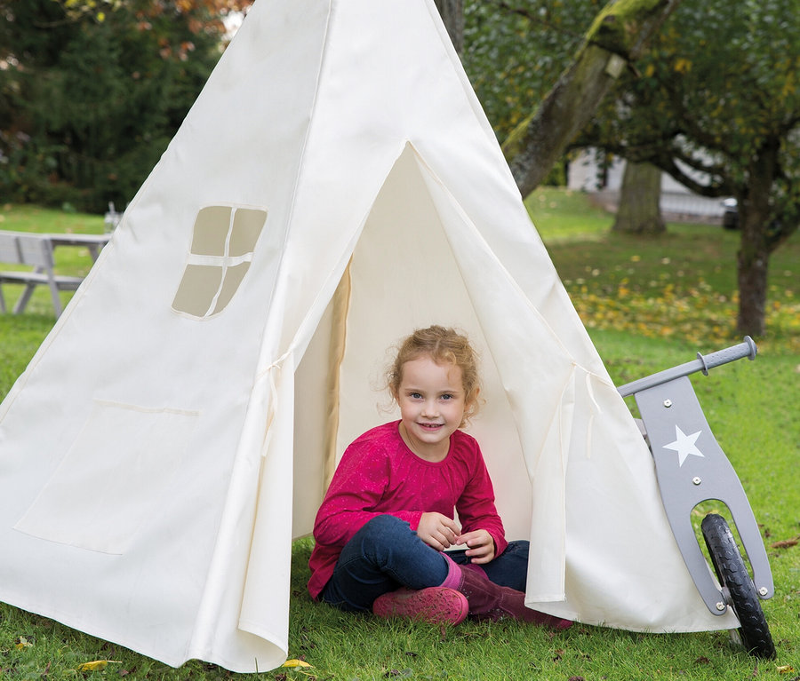 Mädchen sitzt im weißen roba Kinderspielzelt »Tipi«, daneben steht ein graues Laufrad.