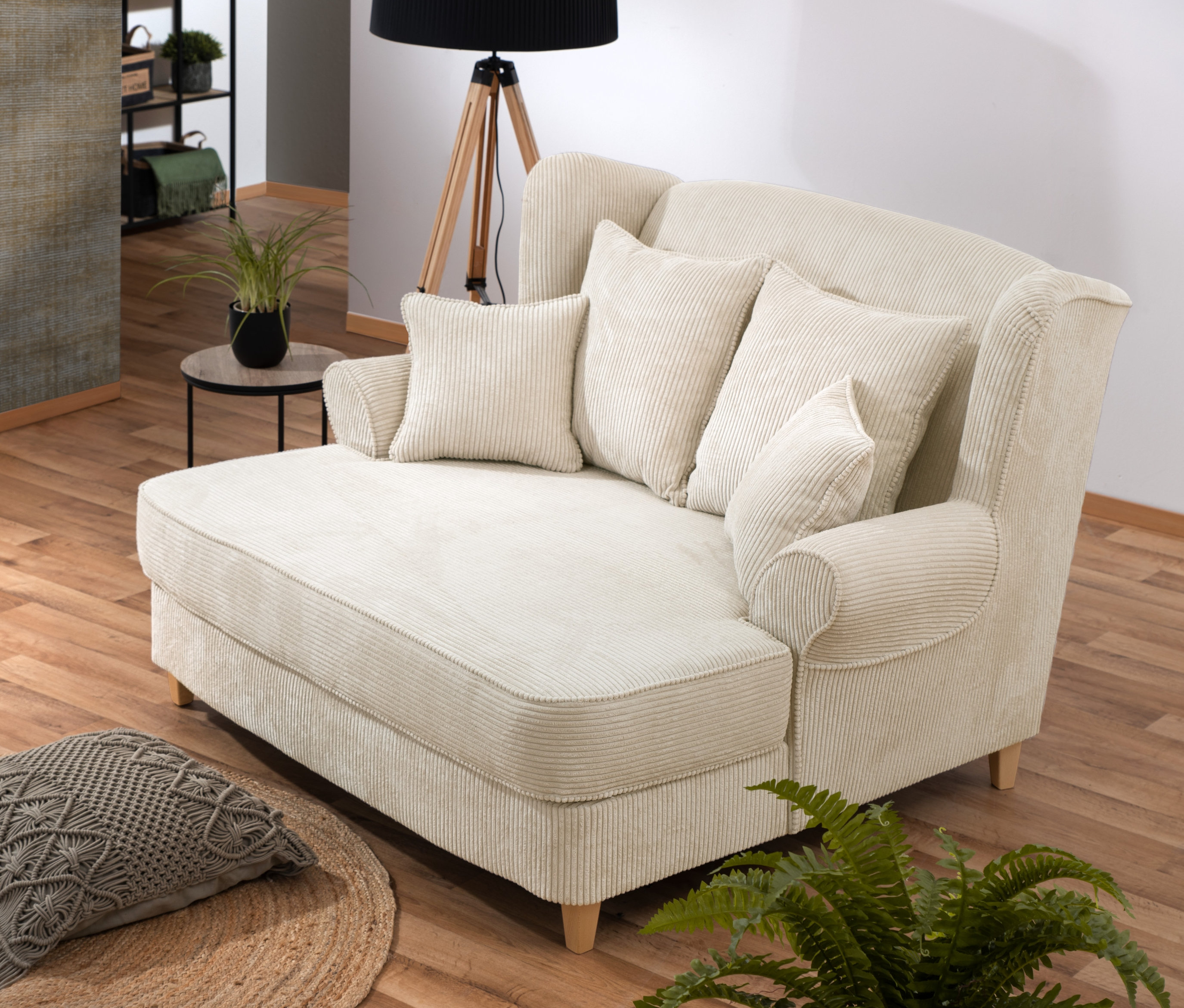 Beiger XXL-Ohrensessel "Harvard" aus Cordstoff mit vier Kissen im Wohnzimmer.