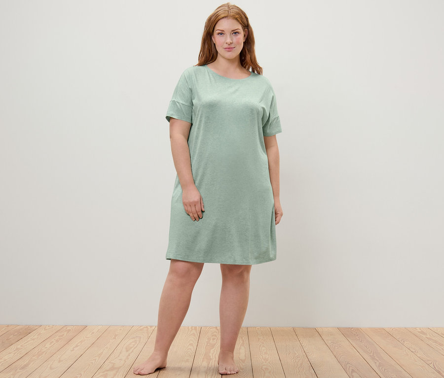 Frau steht und trägt ein Nachthemd.