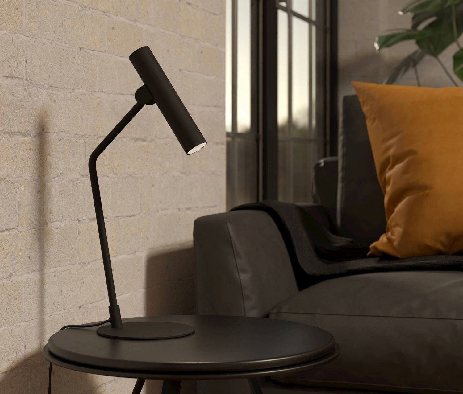 Eine schwarze Eglo Tischleuchte »Almudaina« steht auf einem runden Tisch neben einem grauen Sofa.