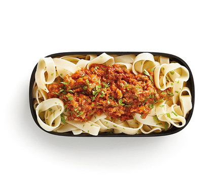 Draufsicht auf eine Lunch-Box-Set mit Besteck, gefüllt mit Nudeln und Soße.