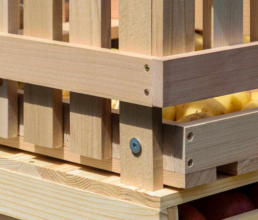 Detailaufnahme eines Vorratsbehälters aus Holz, gefüllt mit Kartoffeln.