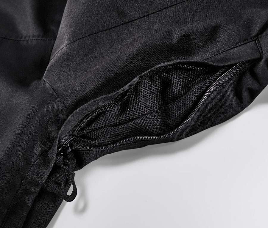 Detailansicht einer schwarzen Skijacke mit Reißverschluss und Netztasche.