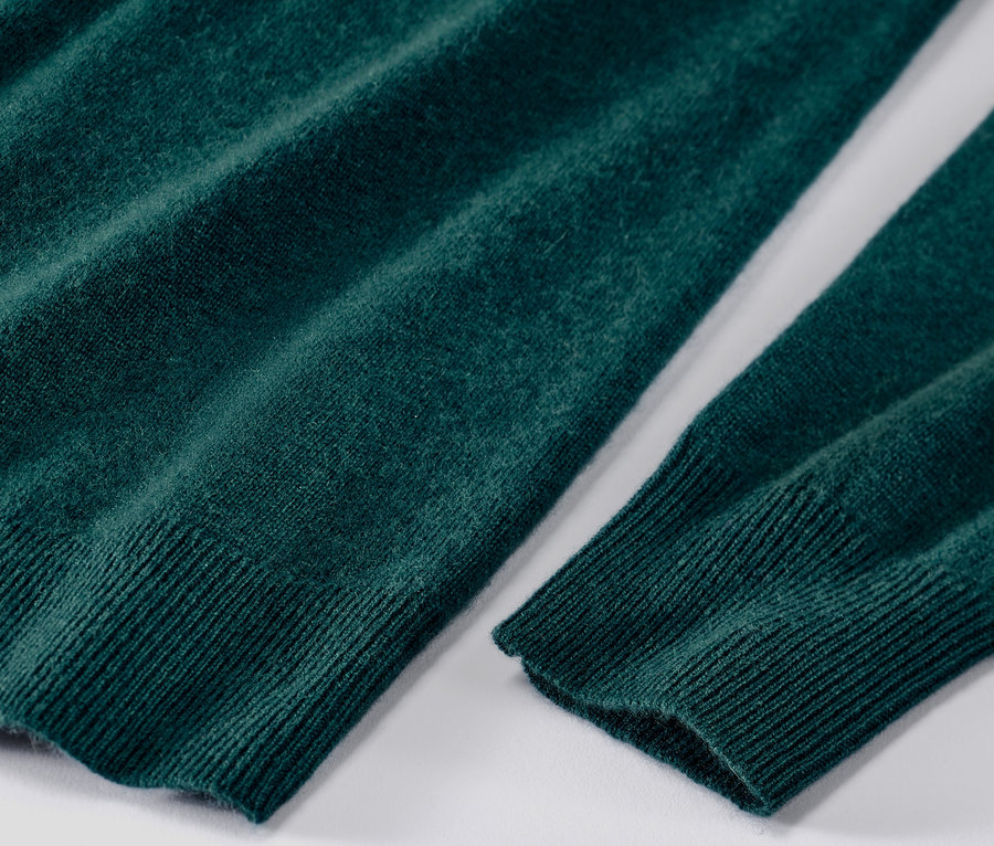 Detailaufnahme eines grünen Feinstrickpullovers mit Cashmere.