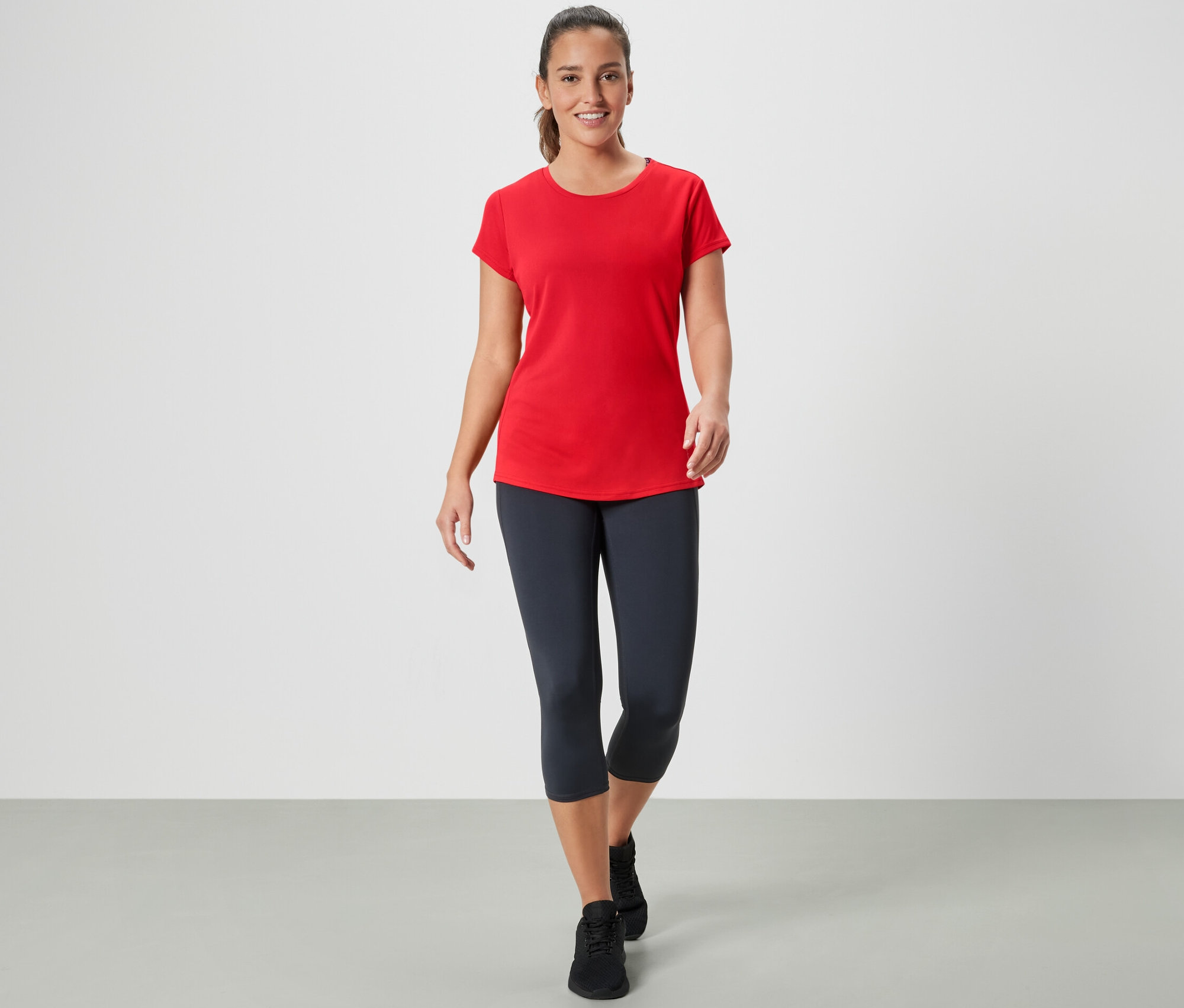 Frau geht und trägt ein rotes Sportshirt.