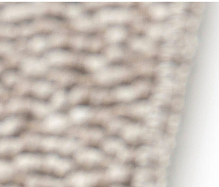 Detailaufnahme eines beigen Teppichs »Twine« mit weichem Chevronmuster.