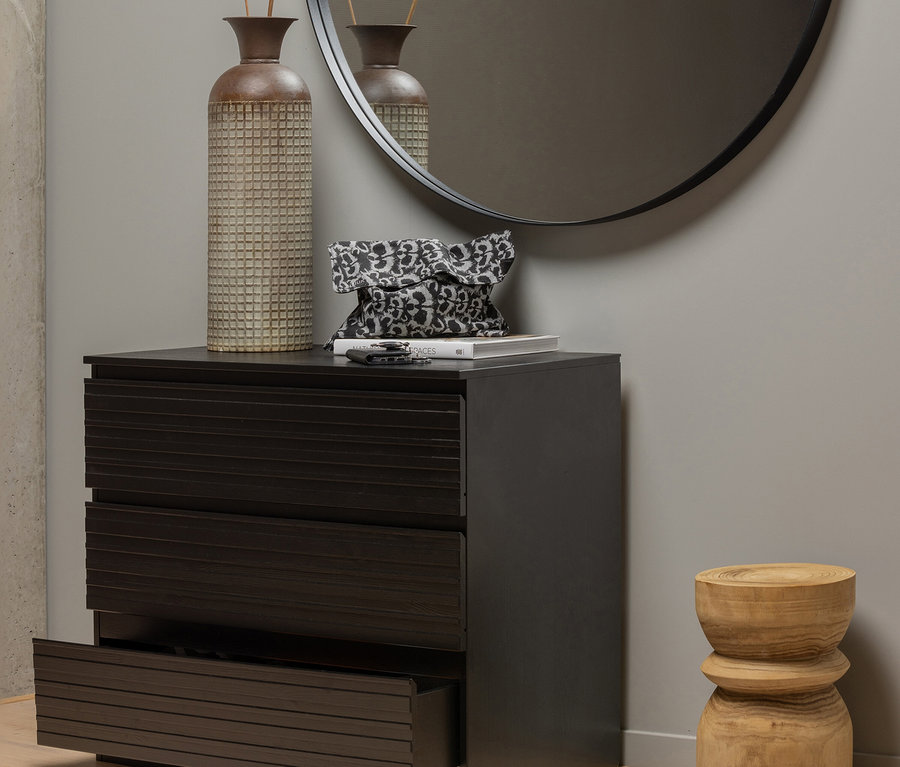 Kommode mit offener Schublade, Vase, Handtasche und Spiegel. Daneben steht ein naturfarbener Woood Hocker »Bikkel« aus Holz.