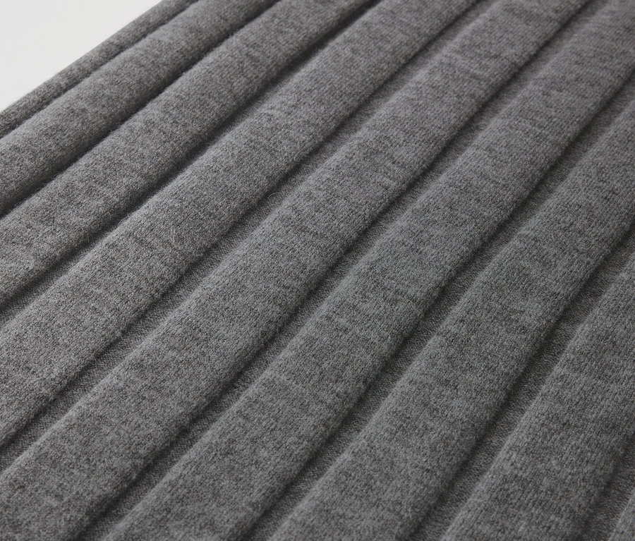 Detailaufnahme eines grauen Faltenstoffs.