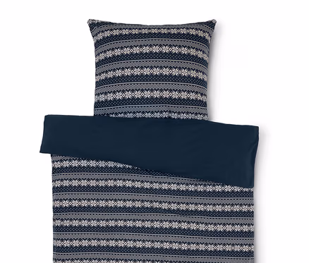 Bettwäsche mit blau-weissem Schneeflockenmuster und einfarbig blauem Bezug.