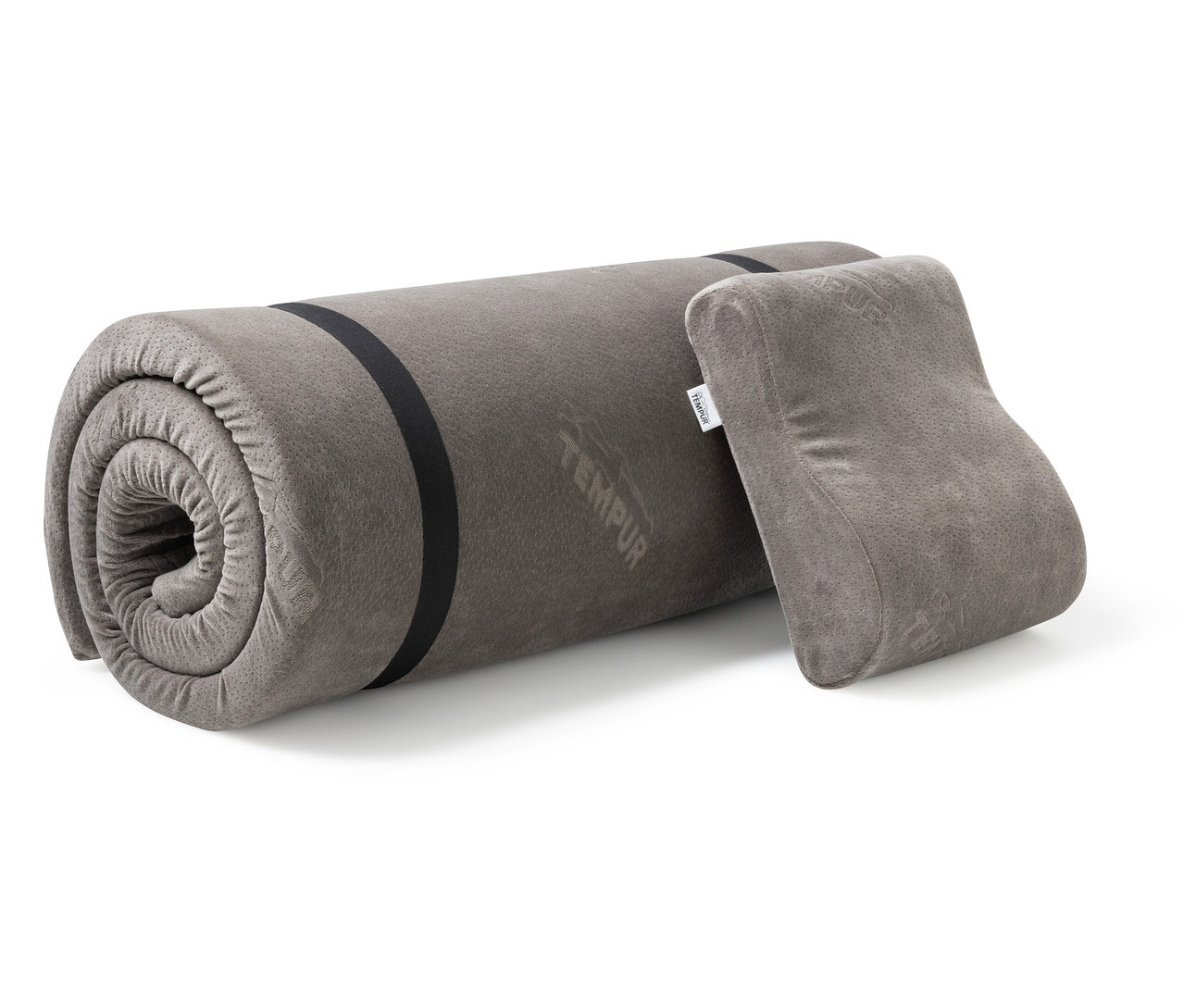 Das TEMPUR® Reiseset, bestehend aus einer zusammengerollten grauen Matratze mit schwarzen Gurten und einem grauen Kissen, liegt auf einem weißen Hintergrund.
