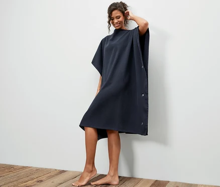 Frau posiert in 2-in-1-Badetuch-und-Poncho.