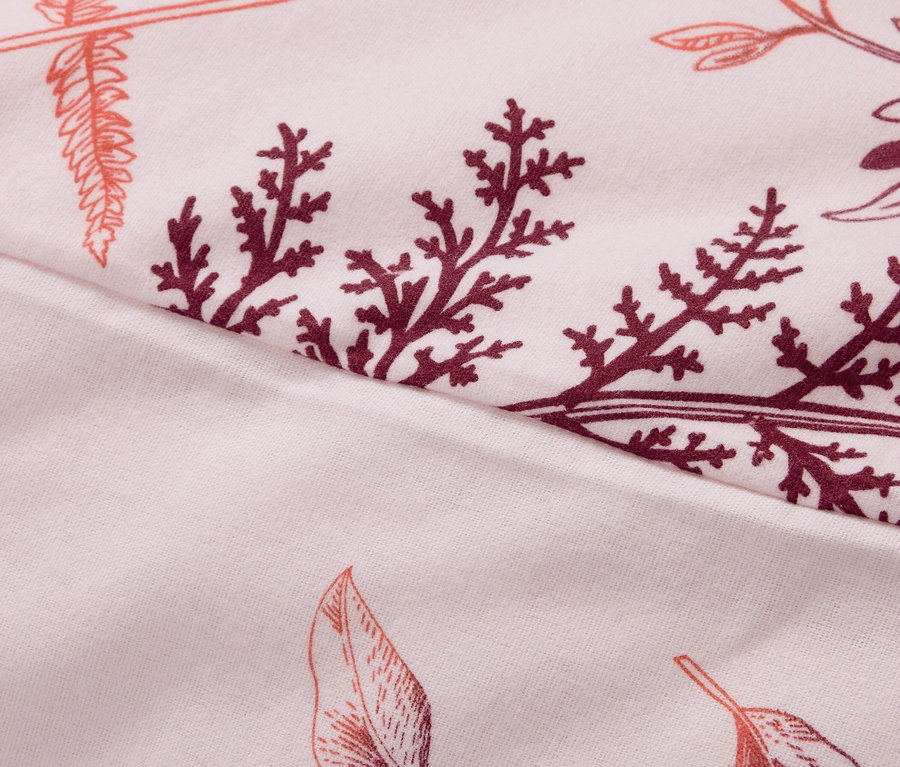 Nahaufnahme eines Stoffes mit Blatt- und Zweigmuster in Rosa- und Burgundertönen.