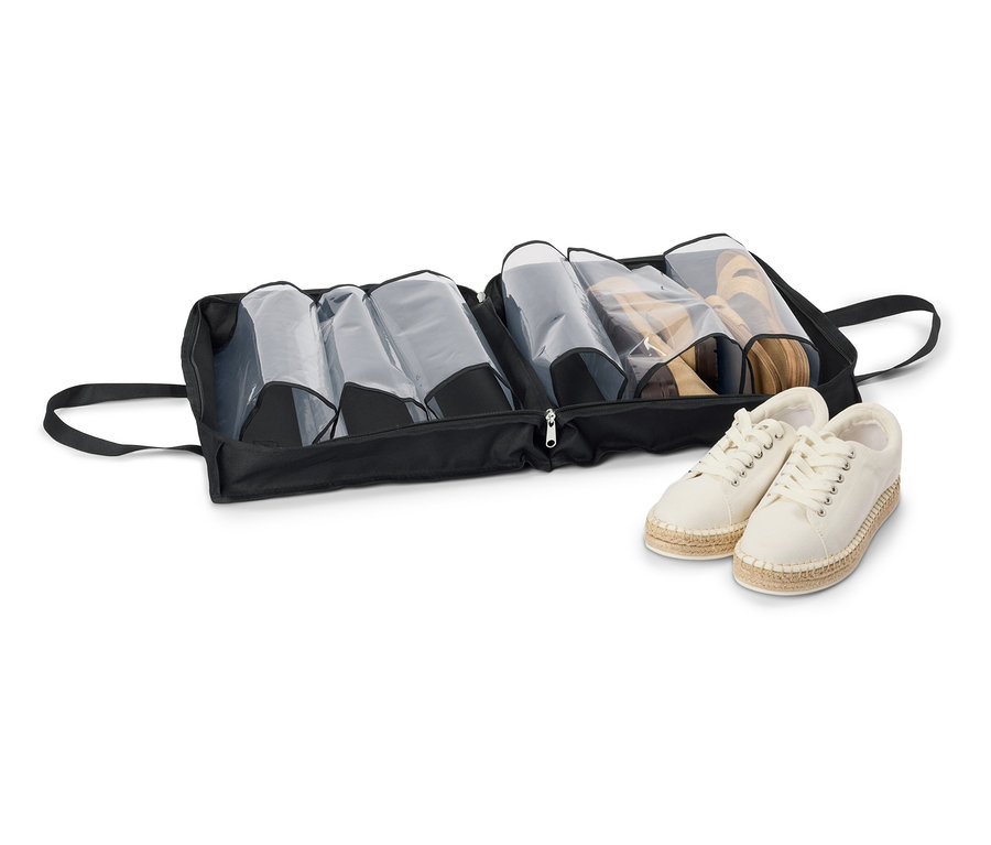 Schwarze Schuhtasche mit Reißverschluss und mehreren Schuhpaaren, darunter beige Espadrilles.