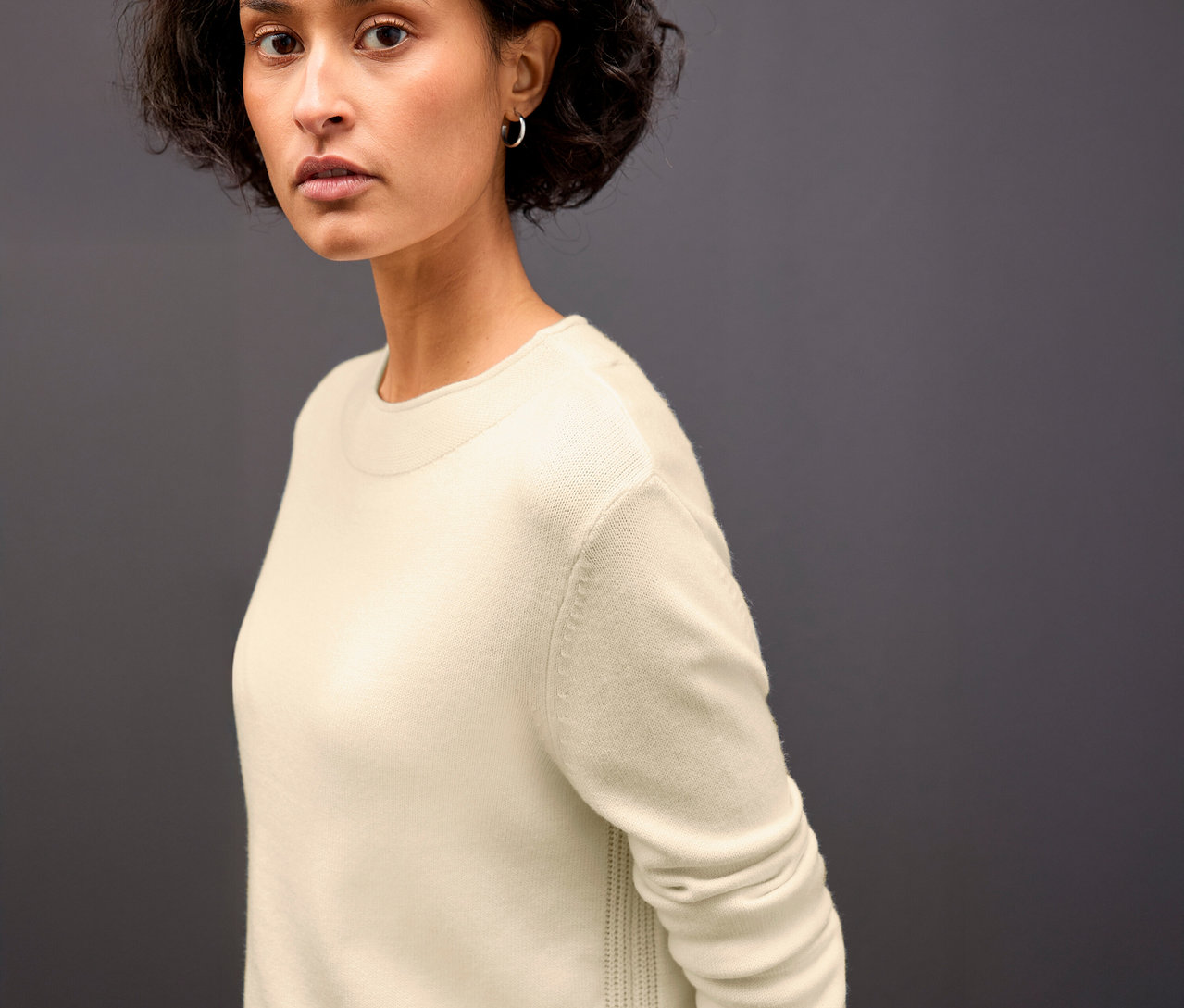 Frau trägt einen beigen Street One Strickpullover mit Rollkante.