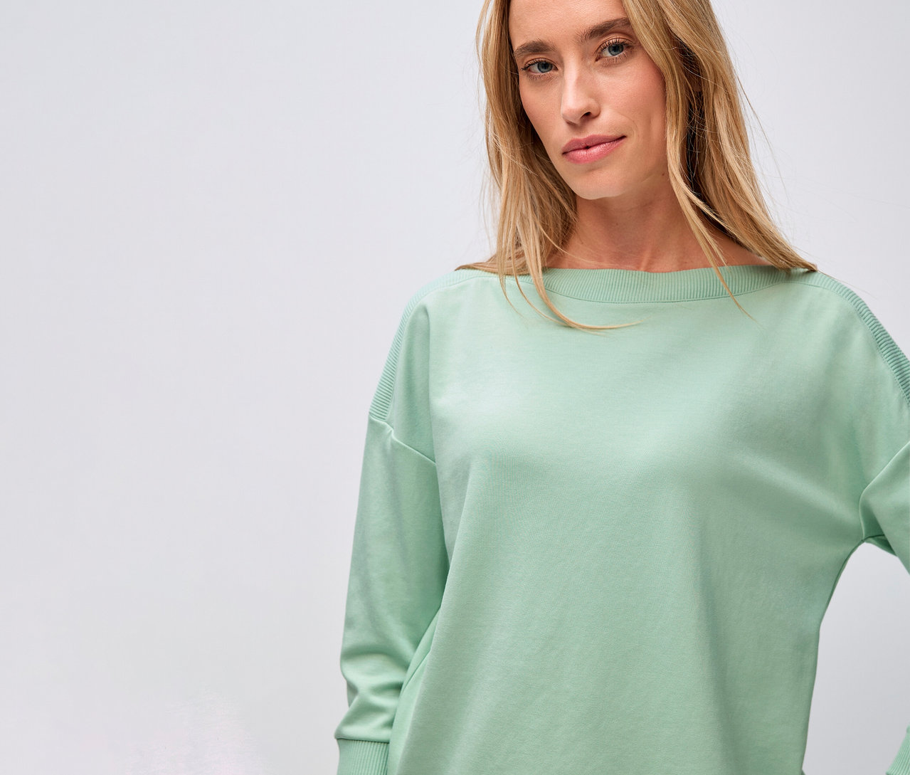 Frau trägt ein Street One, T-Shirt mit Rippdetail, salbeigrün.