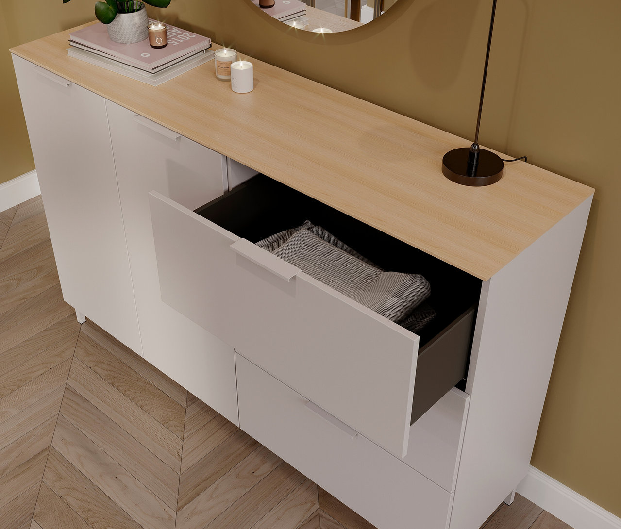 Das Sideboard »Savoca« in Kaschmir/Eiche hat eine geöffnete Schublade, in der ein graues Tuch liegt.