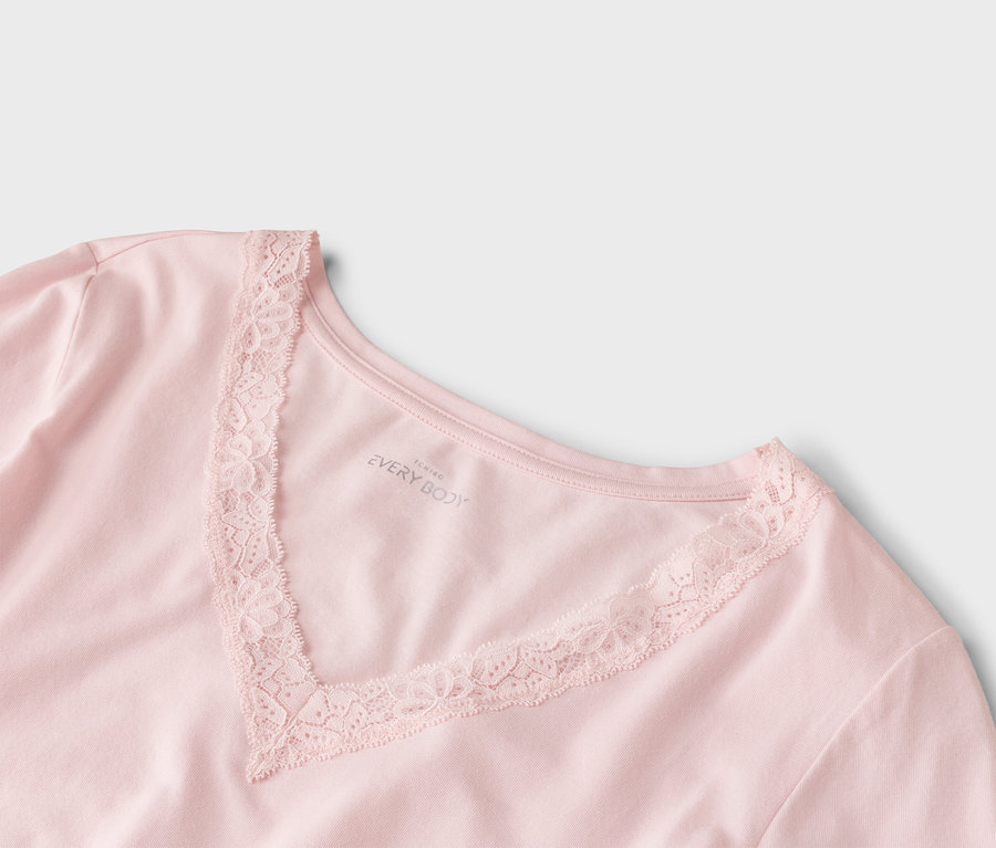 Nahaufnahme eines rosafarbenen T-Shirts mit V-Ausschnitt und Spitzenbesatz.