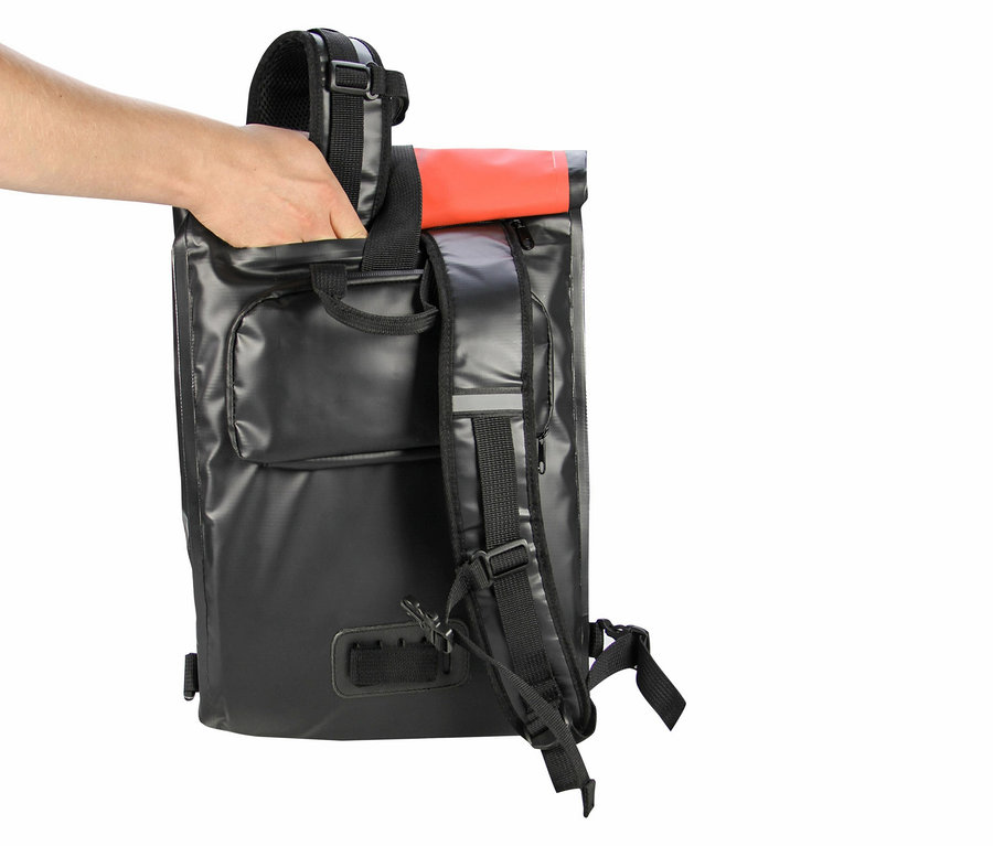 Hand greift in eine schwarze, wasserdichte Roll-Top-Rucksacktasche mit rotem Akzent.