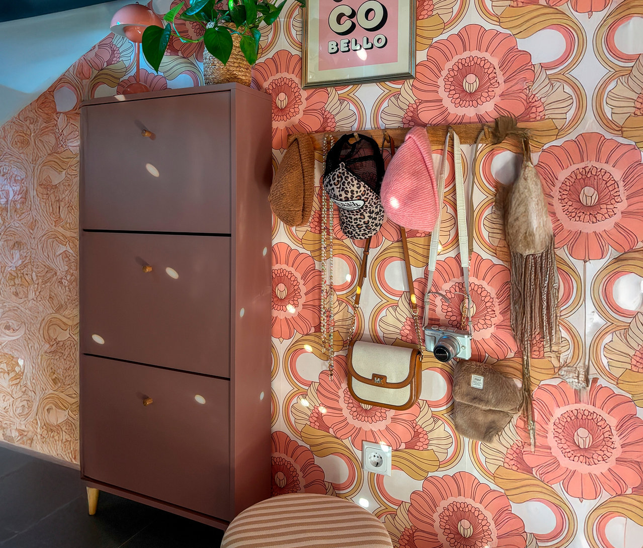 Eine Aufnahme eines Schuhschranks neben einer Wand mit einer Hängeleiste mit Hüten und Handtaschen.