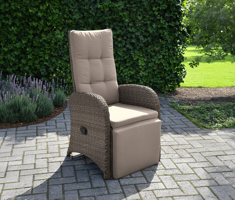 Ein brauner Rattansessel mit beiger Polsterung und ausziehbarer Fußstütze steht auf einer Terrasse.