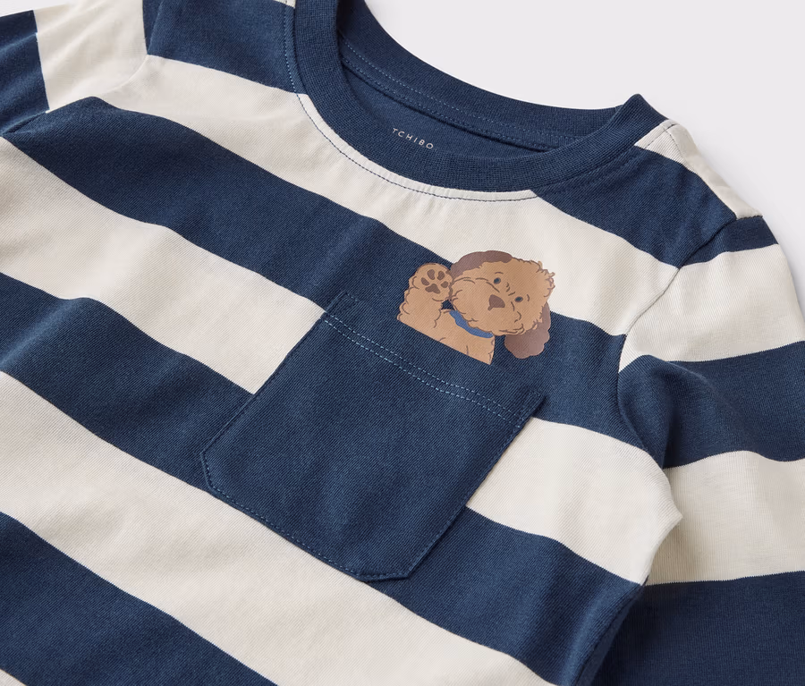 Gestreiftes, langärmliges Shirt mit Brusttasche, aus der ein Cartoon-Hund herausschaut.