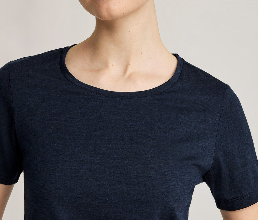 Nahaufnahme einer Person in einem dunkelblauen, kurzärmeligen T-Shirt mit Rundhalsausschnitt.