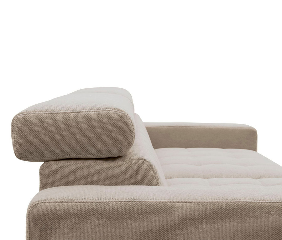 Nahaufnahme einer beigefarbenen Couch mit strukturierter Oberfläche. Die Rückenlehne hat ein verstellbares Kopfpolster und die Sitzfläche ist gesteppt.